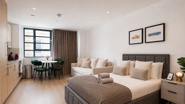 Un dormitorio moderno con una cama grande, un sofá, un comedor y una cocina.