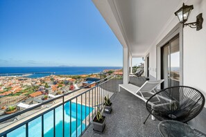 A balcony with a pool, chairs, and potted plants. - São Lourenço Guest House (Machico)