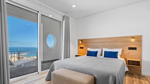 A modern hotel room with a large bed, a view of the sea, and a balcony. - São Lourenço Guest House (Machico)