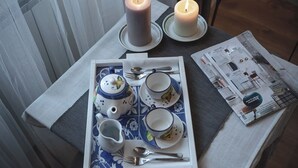 A table set with tea service, two candles, and a magazine. - Casa Lena B&B (Naples)