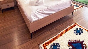 A hotel room with a bed, bedside tables, a coat rack, and a view of the outdoors. - ZAYANE HOMES AGADIR (Agadir)