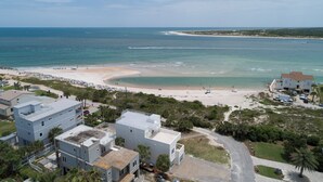 An aerial view of a beach with a sandy shore, a few buildings, and a clear blue sky. - Bright 4BR Home - Just Minutes from town & Beach! (St. Augustine)