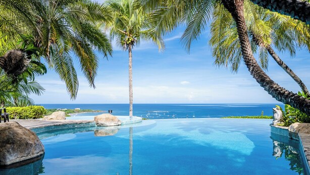 A clear blue infinity pool with a view of the ocean and palm trees. - Ultimate Luxury Villa: Hot Tub, Gourmet Kitchen & Stunning Ocean Views - Fully Staffed (Tamarindo)