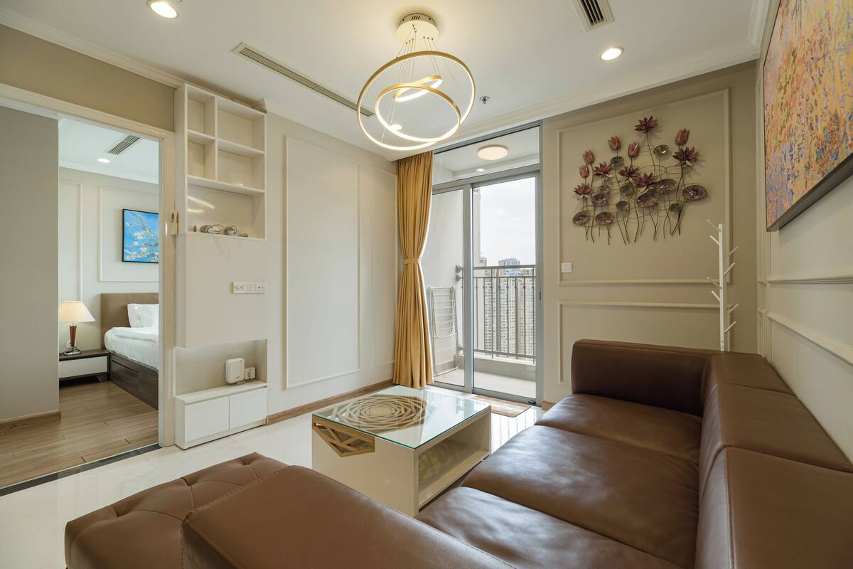Una sala de estar moderna con una mesa de centro de vidrio, sofá de cuero y un gran ventanal con vistas.