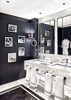 Ein modernes Badezimmer mit dunklen Holzpaneelen, einem großen Spiegel und mehreren gerahmten Fotos.
