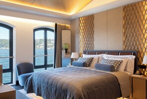 Ein modernes Hotelzimmer mit einem großen Bett, Meerblick und einem Balkon.