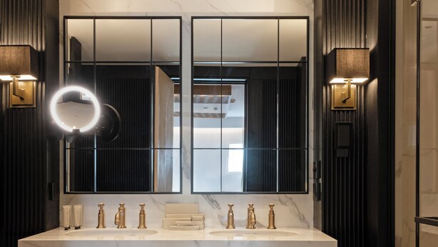 A modern bathroom with a large vanity, double sinks, and a mirror with a circular light. - Vakko Hotel Sumahan Bosphorus (Istanbul)