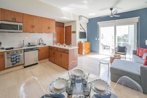 Enjoy meals in the dining area with a glass table set for four, accompanied by clear glassware.