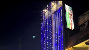 A hotel facade with vertical light strips and a neon sign. - TAJ 3 STAR HOTEL  (Agra)