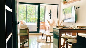 Un salón amplio con un ventanal grande, una mesa de comedor y un televisor montado en la pared.