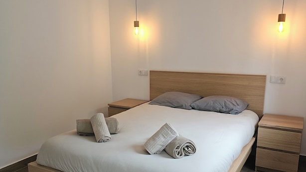 A modern bedroom with a wooden bed frame, two bedside tables, and a headboard. - Destro village  (Lindoso)