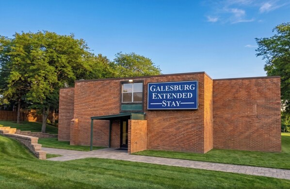 Een bakstenen gebouw met een bord waarop 'Galesburg Extended Stay' staat.