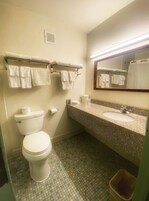 Bañera con ducha, toallas, jabón, shampoo