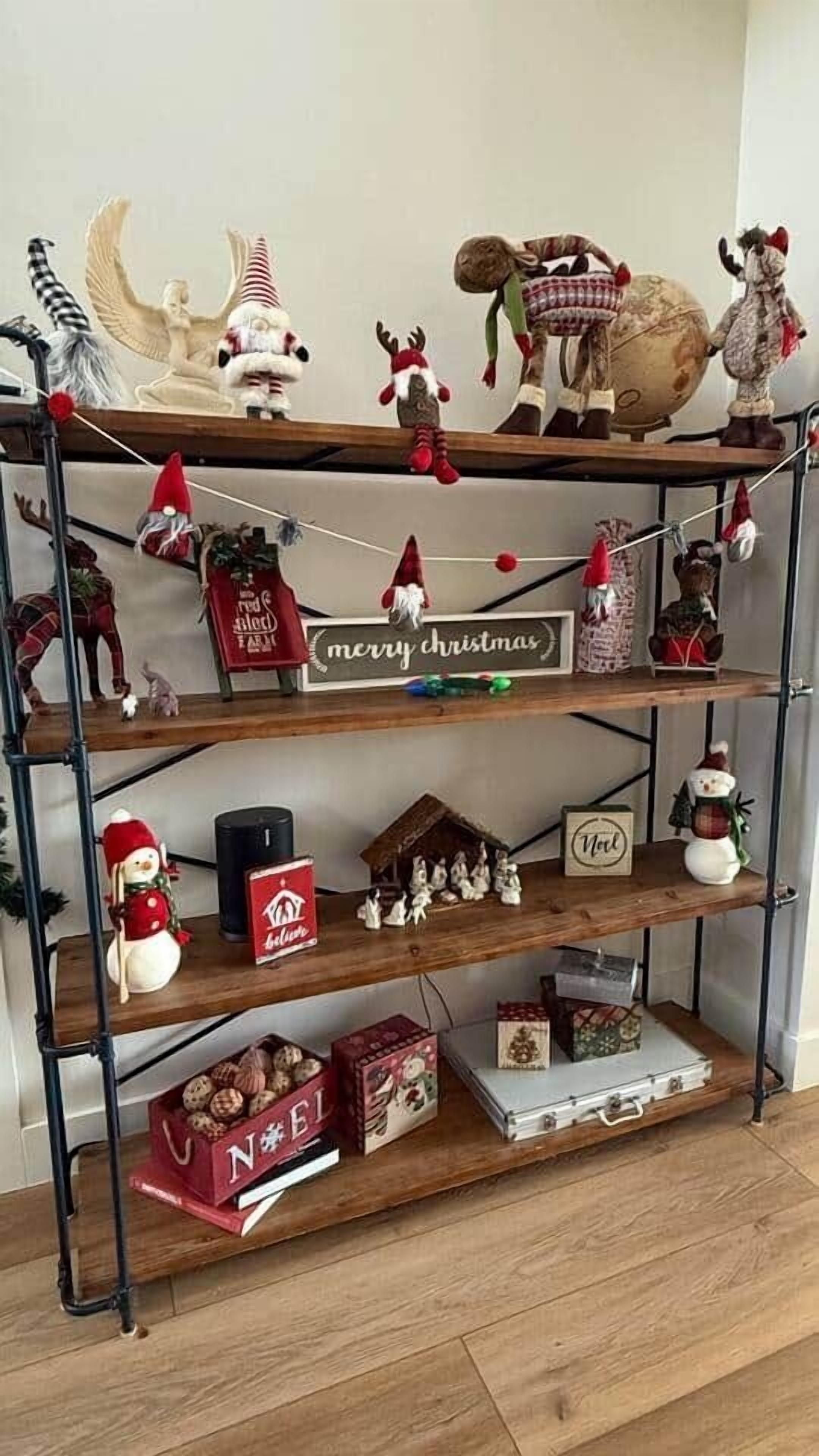 Une étagère en bois décorée pour Noël, avec des figurines, une pancarte indiquant « Joyeux Noël » et une autre indiquant « Entrée interdite ».