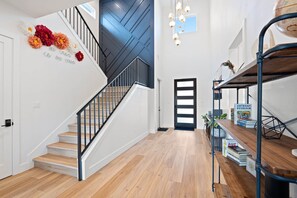 Een modern interieur met een trap, houten vloer, een boekenkast en een wereldbol op een plank.