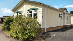 A single-story building with a green roof, a number '40' on the side, and a small garden area with bushes. - 1 bedroom accommodation in Newton Stewart (Newton Stewart)