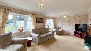 A living room with a sofa set, a television, and a fireplace. - 1 bedroom accommodation in Newton Stewart (Newton Stewart)