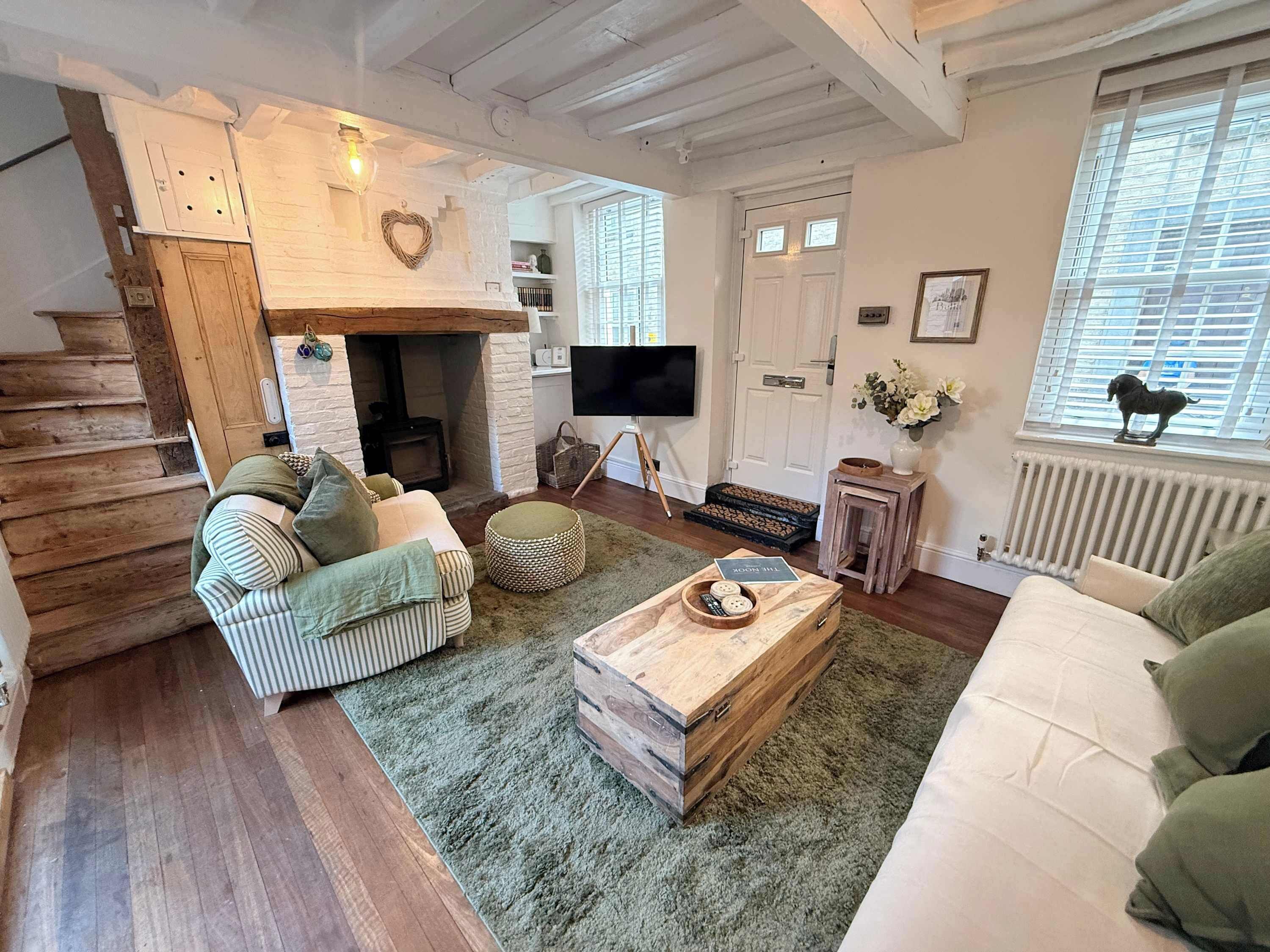 A cozy living room with a fireplace, a sofa, a coffee table, and a television.