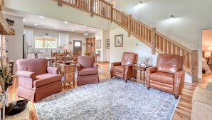 A spacious living room with a high ceiling, wooden staircase, and a view of the kitchen in the background. - Creekside screened porch, pet friendly, minutes to downtown Hayesville. Firewood (Hayesville)