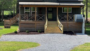 A two-story log cabin with a porch, a chimney, and a gravel driveway. - Creekside screened porch, pet friendly, minutes to downtown Hayesville. Firewood (Hayesville)