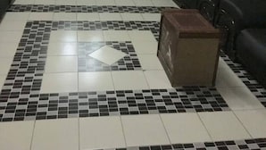 A lobby with a tiled floor, a chandelier, a reception desk, and a seating area with sofas. - Image Classic Hotel (Kwabenya)