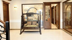 A four-poster bed with a canopy, a wooden staircase, and a glass door leading to a room with a chandelier. - Spanish Villa/5 BHK/Raya Golf course & Cinema 2Kms (Lahore)