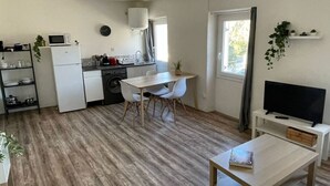 A compact living space with a kitchen, dining area, and a TV. - Large Studio 100m from the beach (Toulon)