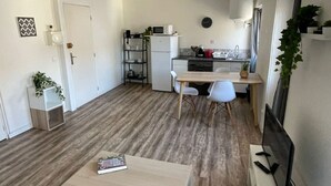 A compact living space with a kitchenette, a dining area, and a workspace. - Large Studio 100m from the beach (Toulon)