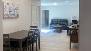 A dining area with a table and chairs, a living room with a sofa and a coffee table, and a painting on the wall. - Charming, Newly remodeled, 3+Br/2Ba house, with office, in Meridian (Meridian)
