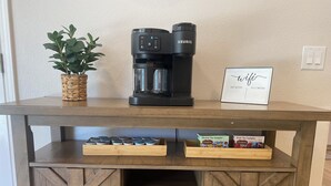 A wooden coffee table with a Keurig coffee maker, a WiFi password sign, and herbal and fruit tea samplers. - Charming, Newly remodeled, 3+Br/2Ba house, with office, in Meridian (Meridian)