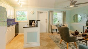A compact kitchen with a dining area, a ceiling fan, and a view of the outdoors. - Sunny Retreat: Cozy APT in WPB #2 (West Palm Beach)