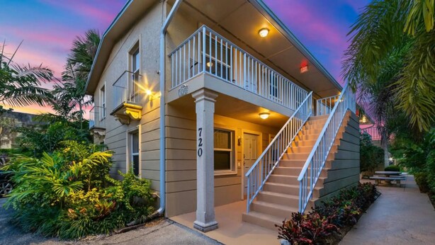 A two-story house with a balcony, a staircase, and a well-maintained garden. - Sunny Retreat: Cozy APT in WPB #2 (West Palm Beach)