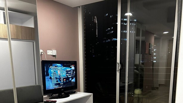 A modern living room with a flat-screen TV, grey sofas, and a wooden cabinet. - Loft Centro Internacional y Terraza 211 (Bogotá)