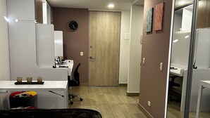 A modern hotel room with a bed, a desk, a chair, and a wardrobe. - Loft Centro Internacional y Terraza 211 (Bogotá)