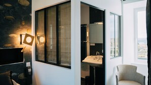 A modern bathroom with a large window, a sink, and a chair. - les agapanthes (Ploubazlanec)