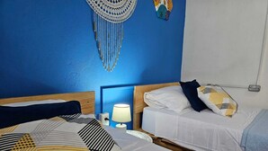 Een kamer met twee bedden, een wanddecoratie en een bedlampje.