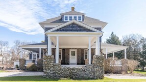 A two-story house with a stone foundation, a covered porch, and a gabled roof. - Gorgeous Spacious Victorian Cape Cod Beach View Retreat (Falmouth)