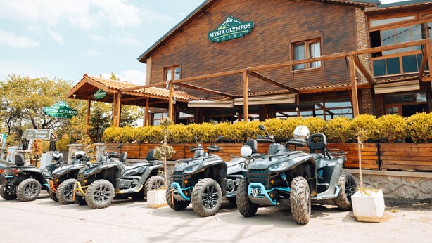Un edificio in legno con un cartello che riporta la scritta "MYSIA OLYMPOS HOTEL".