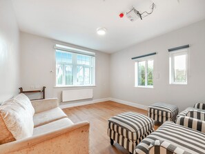 A spacious room with a large window, a radiator, and striped ottomans. - The Old Doctors Manor House (Whitstable)