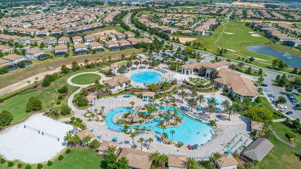 An aerial view of a resort with multiple swimming pools, a golf course, and residential areas. - Luxury 6BR Escape – Pool, Water Slides & Lazy River Near Disney! (Four Corners)