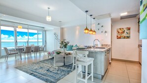 A modern kitchen with a large island, white cabinetry, and pendant lighting. - Beautiful 2-bedroom condo in fabulous Guayacanes with WiFi, AC (Guayacanes)