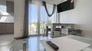 Uma sala de estar moderna com uma mesa de vidro, um controle remoto e um aviso com a senha da rede.