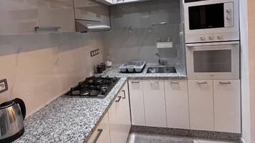 Cafetera o tetera, utensilios de cocina y mesa de comedor