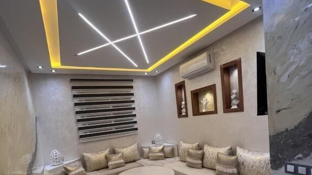 A modern living room with a sectional sofa, a round coffee table, and a decorative rug. - Modern, elegant and comfortable apartment in Marrakech (Marrakech)
