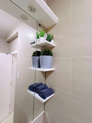 Une salle de bain avec un miroir, un porte-serviettes et des plantes en pot.