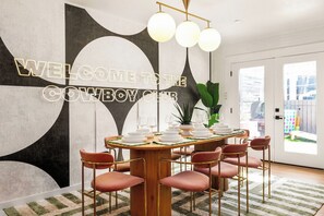 Ein Essbereich mit einem runden Tisch, gedeckt für sechs Personen, umgeben von sechs modern gestalteten Stühlen.