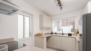 A modern kitchen with a built-in stove, a sink, and a refrigerator.