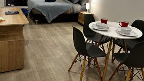 A modern bedroom with a bed, bedside table, and a small desk area with chairs. - Hermoso apartamento con vistas 312 (Bogotá)