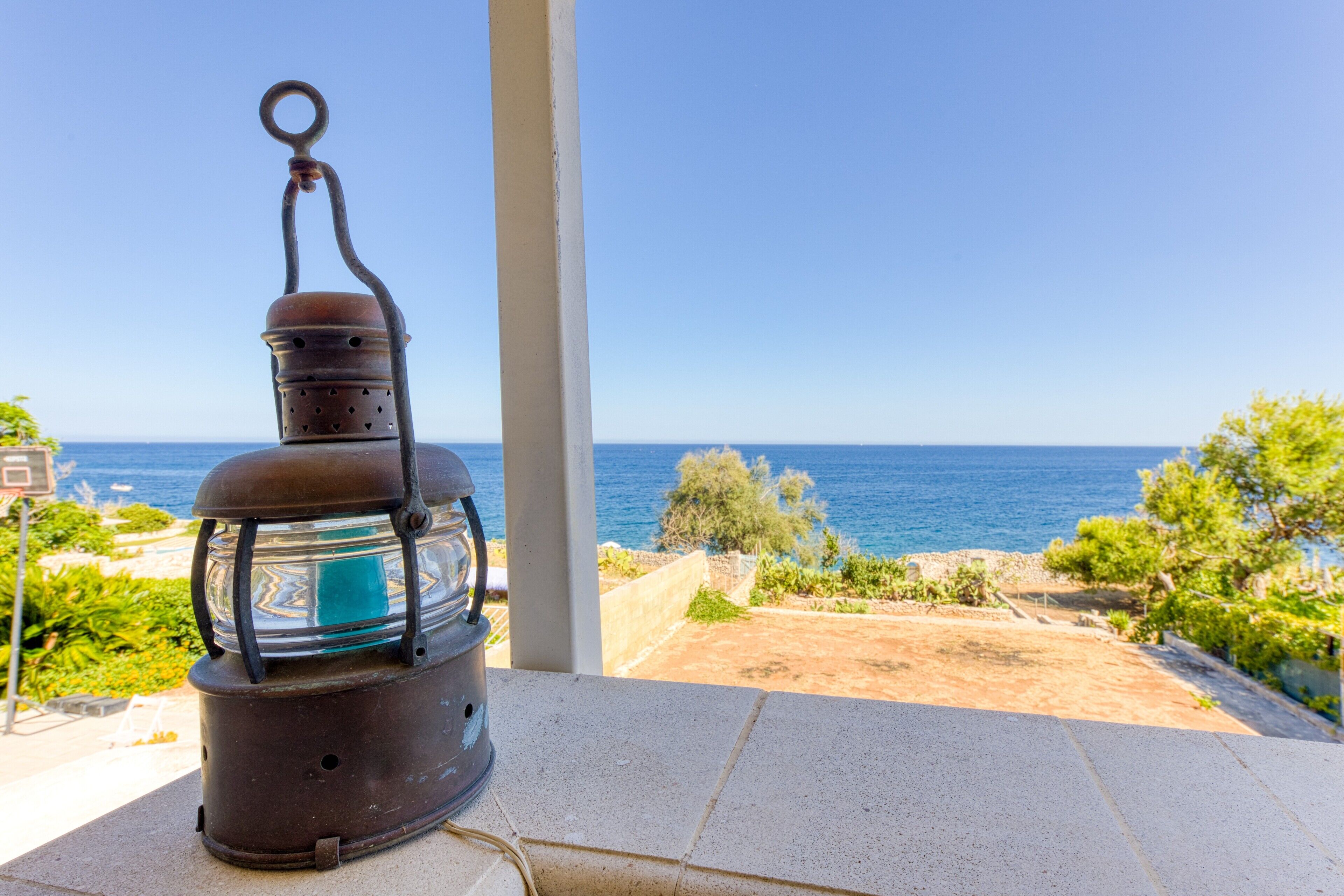Una lanterna su un balcone con vista sulla costa.