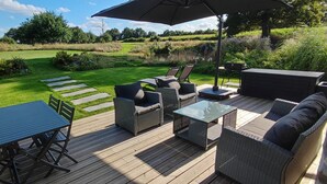 Eine Terrasse im Freien mit Tisch, Stühlen und einer Couch.